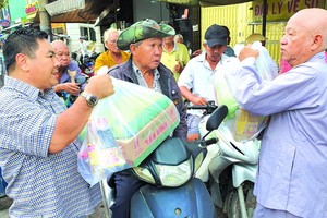 丁文森（左一）與李庭輝代表向窮人派禮物。