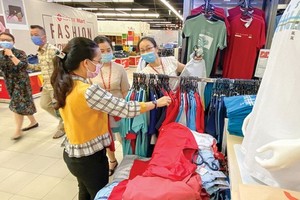 消費者在超市選購國產服裝。