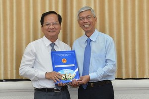 陳文勸同志（左）從市人委會副主席武文歡手中接過人事委任《決定》。（圖源：越勇）