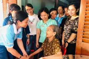 第五郡越華婦女團向阮氏景越南英雄母親贈送存摺。