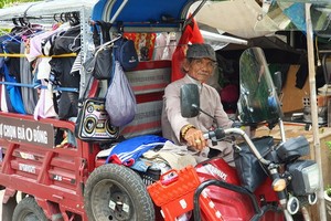 四隱先生駕著載滿衣服的電動三輪車走遍各條大街小巷去派發。