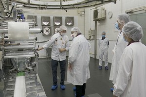 高肇力總經理（左一）向美國駐本市總領事館代表團介紹月餅生產線。