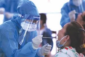 防疫工作人員對返回本市的遊客採樣檢測新冠病毒。（圖源：互聯網）