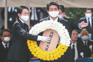 日本首相安倍晉三（中）9日在長崎市原爆75周年紀念儀式獻上花圈。（圖源：AFP）