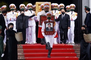 政府總理阮春福與國會主席阮氏金銀護送原總書記黎可漂靈柩上靈車。（圖源：越通社）