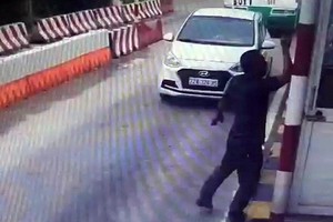 司機下車走近收費亭高舉起手向女收費員摑了一巴掌。（圖源：監控視頻截圖）