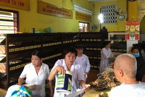 興光寺診所的醫生們正為病人抓藥。