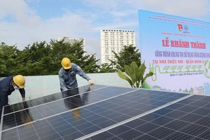 年輕電工正在第四郡少兒文化宮安裝屋頂太陽能光電板。