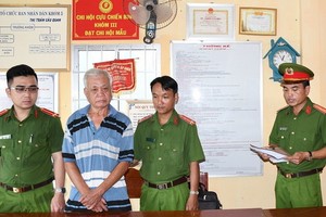 涉案嫌犯陳金利（左二）站立著聽取執法警員宣讀拘捕令。