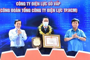 《西貢解放報》執行副總編輯阮玉英(左)向模範技師武輝俊頒獎。（圖源：越勇）