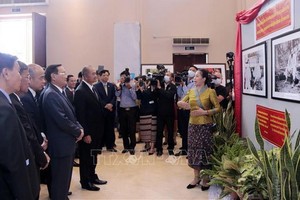 與會代表觀賞越老合作關係圖片展。（圖源：越通社）