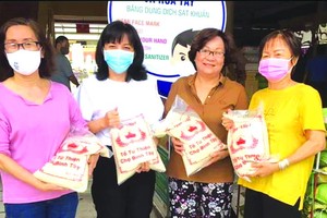 華人商販應氏蓮（右一）與各商販在準備向貧困者派發大米。