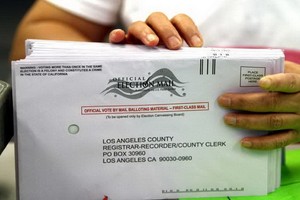 一名職員在辦公室對郵寄選票進行分類。（圖源：洛杉磯時報）