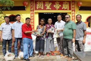 決勝村關帝廟理事長楊振明(左三)、副理事長兼財政陳昶霖(右三)與諸位理事 向貧困者派發賑濟品。