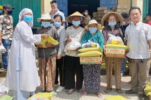 鄒國榮(右一)向貧困者派發禮物。