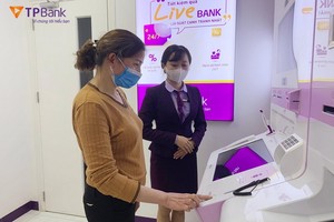銀行職員正旨引客戶操作LiveBank 進行交易。