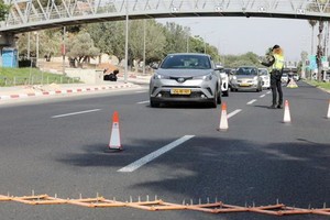 9月18日，在以色列中部城市特拉維夫，一名警察在一處檢查點執行“封城”任務。