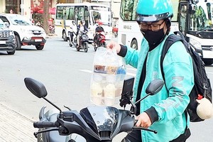 送貨員送一次性塑料杯裝的咖啡。