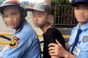 少年（坐在中間）在舊邑郡某商業中心女廁偷拍，被保安力量抓獲。