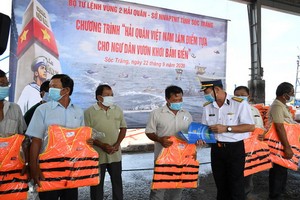 海軍第二區司令阮英俊大校向滀臻省漁民贈送救生衣。（圖源：明勝）