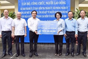 市越南祖國陣線委員會主席蘇氏碧珠（右三）象徵性接領由市委常務副書記陳留光（左三）移交的“為窮人”基金活動經費。（圖源：市黨部新聞網）