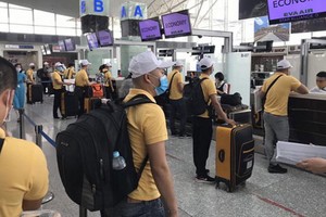 赴馬來西亞工作的勞工在機場辦理登機手續。（圖源：江南）