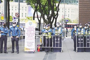 大批警察在首爾光化門廣場附近設置路障，禁止隨意出入；路上貼有通知，稱根據傳染病相關法規，禁止集會，違者將被處以罰款。（圖源：互聯網）