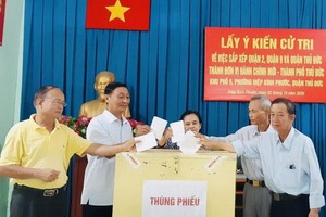 守德郡協平福坊居民對第二、九、守德郡合拼事項進行投票。（圖源：VNN）