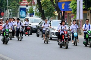 學生騎電動車，但不戴安全帽。