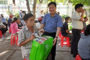 第五郡越南祖國陣線委員會主席黎晉才送禮物給貧困戶。