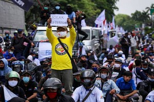 印尼國會通過爭議性法案修正，大批勞工上街示威抗議。（圖源：路透社）