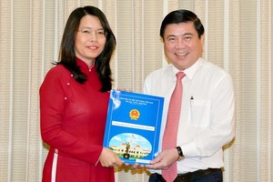 新任市旅遊廳長阮氏映華（左）從市人委會主席阮成鋒手中接過人事委任《決定》。
