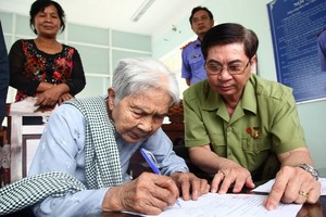 武氏商老大娘簽領冤案精神損害賠償金。（圖源：江芳）