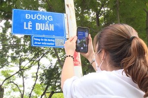 一名女遊客拍攝黎筍街名指示牌，以進一步了解該街名的歷史資訊。（圖源：明君）