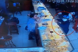 一名戴著口罩的男子走進金舖佯裝購買黃金，趁店員不備時，搶走了價值1億元的金飾。（圖源：監控視頻截圖）