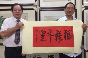 人民藝人張漢明(右)送墨寶給高維山副主席。