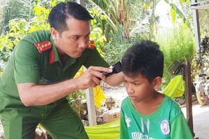 石平大尉正為小朋友理髮。