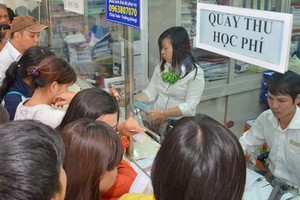 學生家長為子弟繳交學費。（示意圖源：何玲）