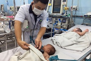 市第一兒童醫院醫生在給一名入住醫院重症監護室接受治療的手足口病童查體。（圖源：舒英）