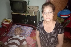 朱潔明與癱瘓在床的父親朱堅。