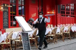 巴黎蒙馬特高地小丘廣場服務員在一家餐館外忙碌。（圖源：新華社）
