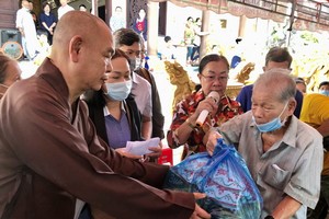 第八郡紅十字輔助會會長釋慧功上座向貧困長者贈送禮物。