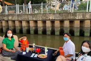 遊客坐船遊覽饒祿-氏藝涌兩岸風光。