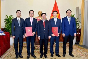 政府副總理、外交部長范平明（中）向任命的總領事頒授《決定》並合影留念。（圖源：VOV）