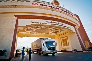 一輛運載貨品的集裝箱卡車經勞保國際口岸通關後運往老撾。（圖源：江阮）