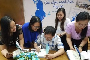 作家阮日映在新書簽名送給讀者。