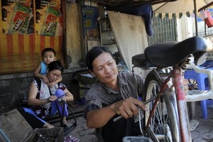 何文鴻正在修車謀生。