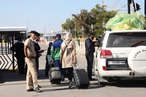 11月14日，在利比亞與突尼斯交界的拉斯傑迪爾口岸，來自利比亞的人員準備入境突尼斯。（圖源：新華社）