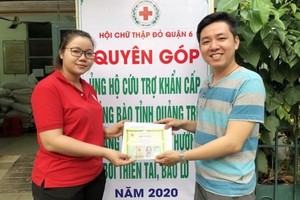 曾廣健(右)把籌到的善款移交給第六郡紅十字會會計黎氏紅雲。