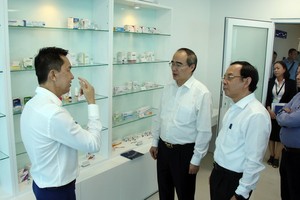 黨中央政治局委員阮善仁與市委書記阮文年參觀園區內企業。（圖源：越通社）